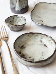 A set of cutlery and tableware on a linen tablecloth. Serving option. Light background, top view.