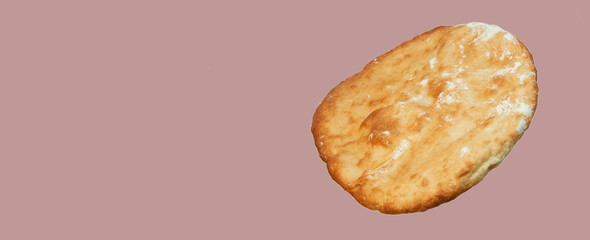 round georgian pita bread on a pink background. round flat bread on a light surface	