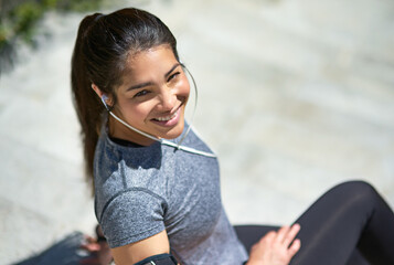 Happy woman, portrait and fitness with headphones for break, relax or listening to music on stairs...