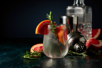 Cocktail gin tonic with ice, grapefruit, and rosemary.