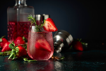 Cocktail with ice, strawberries, and rosemary.