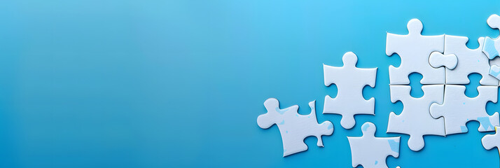 Fototapeta premium A white jigsaw puzzle on a blue background with blank space for an image. Creative banner. Copyspace image
