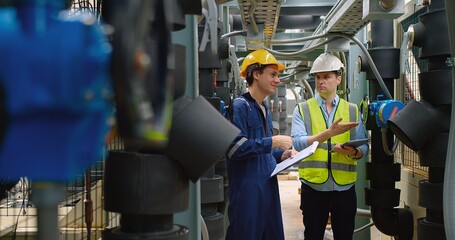 Civil engineer manager and foreman worker checking industry cooling air conditioner water cooling tower air chiller of large industrial building to control air system at construction site