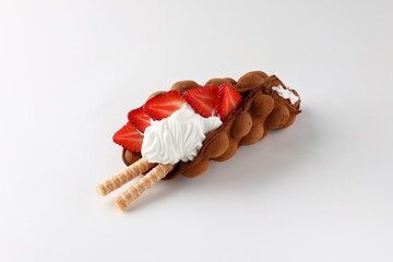 Hong kong or bubble waffle with ice cream, chocolate, marshmallows and strawberries isolated on white background