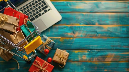 A mini shopping cart filled with gift bags placed on a laptop, surrounded by wrapped presents on a festive wooden table, representing online holiday shopping.
