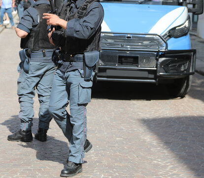 italian police officers patrolling the city street and police van
