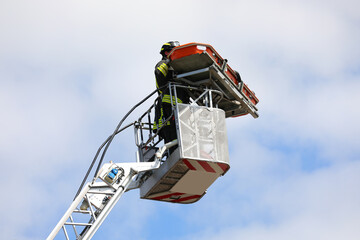 Firefighters on board an aerial platform with suspended stretcher during the rescue of the injured person