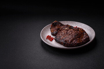 Delicious juicy beef ribeye steak grilled with salt, spices and herbs