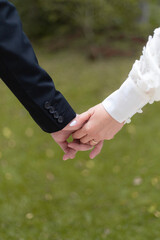 bride and groom holding hands, grass background
