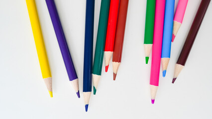 Colorful pencils on a white background, perfect for art development.