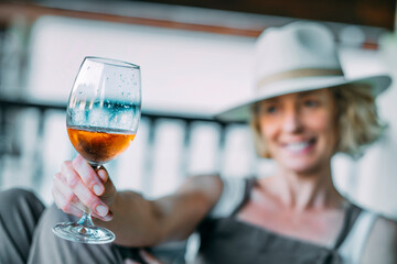 A woman is holding a wine glass and smiling.