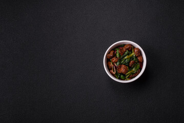 Delicious warm salad with pieces of meat, spinach, tomatoes, salt, spices and herbs