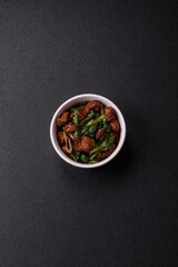 Delicious warm salad with pieces of meat, spinach, tomatoes, salt, spices and herbs