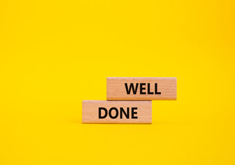 Well done symbol. Wooden blocks with words Well done. Beautiful yellow background. Business and...