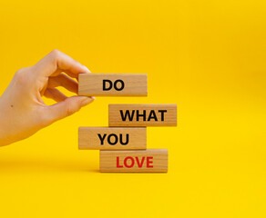 Do what you Love symbol. Concept words Do what you Love on wooden blocks. Beautiful yellow background. Businessman hand. Business and Do what you Love concept. Copy space