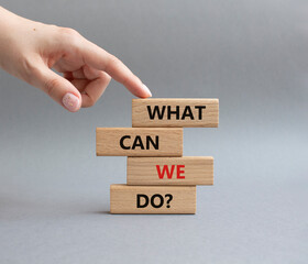 What can we do symbol. Wooden blocks with words What can we do. Businessman hand. Beautiful grey background. Business and What can we do concept. Copy space.