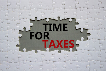 Time for Taxes symbol. Concept words Time for Taxes on white puzzle. Beautiful grey background with...
