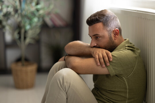 Man sitting alone at home looking sad and distraught