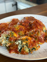 Malfatis de ricota y espinaca con tuco de salsa de tomate, estofado y salchicha.