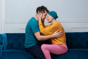Husband and ill of cancer wife share tender moment on a sofa
