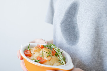 Close up dirty grease stain on gray clothes. An unrecognizable woman holding salad in hands. space...