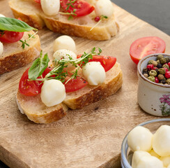Round mozzarella, cherry tomatoes and microgreens on a piece of white bread, a healthy sandwich