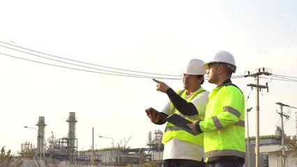 Two engineers working at an industrial plant,power generation facility,discussing operational issues,collaboration between manager and electrical engineer,solving technical problems,ensuring efficient