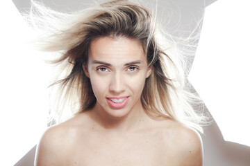 Vibrant young woman with flowing hair and radiant smile under studio lighting