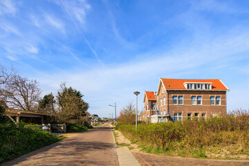 Clinker-built houses in the Dutch town of Bergen aan Zee on a sunny day with a blue sky