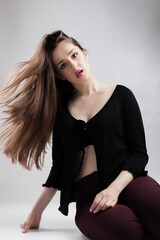 Stylish young woman with flowing hair posing in a casual outfit