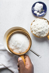 Overhead view of bowl of white sugar, top view of granulated sugar in a brown ceramic ramekin