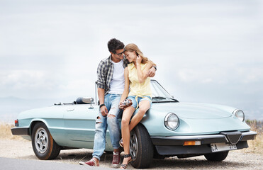 Love, car and couple with camera for holiday, road trip journey and happiness for relationship trust. Outdoor, man and woman by auto convertible with photography and honeymoon vacation in France