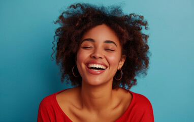 Portrait of a laughing woman isolated on a blue background.

