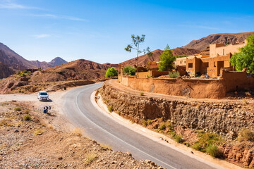 Car on scenic road in desert mountain landscape of Dades valley, Morocco, North Africa