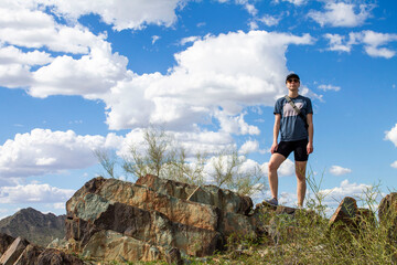 Woman poses on a rock formation at the Arizona Mountain Preserves