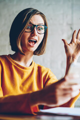 Emotional young woman feeling amazed checking email box receiving message with discount in web...