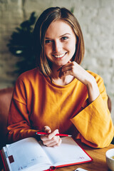 Half length portrait of beautiful cheerful student with stylish short haircut smiling at camera...