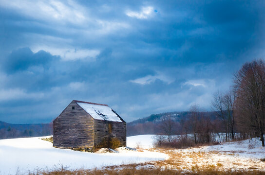 The Great American Barn at sunset in a snowfield with storm clouds