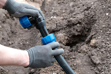 A master plumber installs a water supply system from HDPE pipes, installs a compression fitting at...