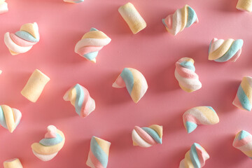 Marshmallows lined up on a pink background.