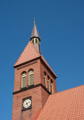 Fototapeta premium The clock tower and the tiled roof of the Lutheran church