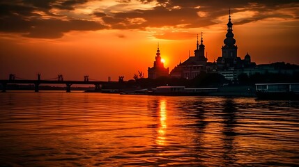 Stunning sunset over a tranquil river with silhouette of a historic temple and bridge reflecting vibrant orange hues in the sky and water creating a serene and picturesque evening scene.