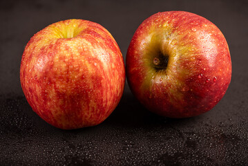 Beautiful apples placed on dark reflective surface, selective focus.