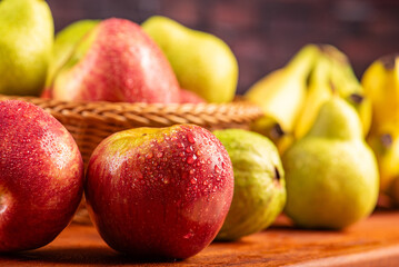 Basket with fruits on rustic wooden surface and dark background, selective focus.