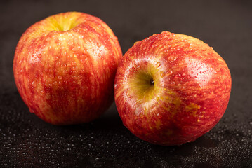 Beautiful apples placed on dark reflective surface, selective focus.