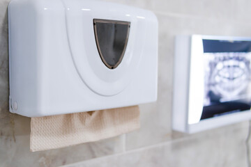 Napkin dispenser for clients in the dental office, with a radiography viewer in the background,...