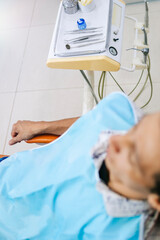 An overhead shot of a patient in a dental office, showing a large part of the clinic and dental work equipment