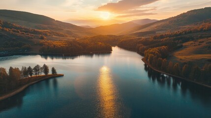 High angle aerial shot of stunning lake with mountain forest scenery at sunset or sunrise