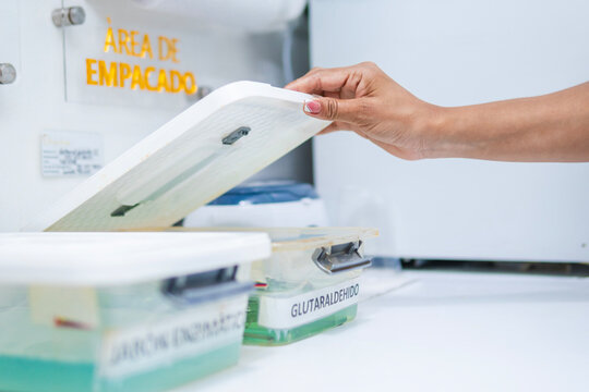 Dental assistant takes dental implements from their cleaning area, where they are immunized against bacteria. The implements are then sterilized in Glutaraldehyde in the packaging area