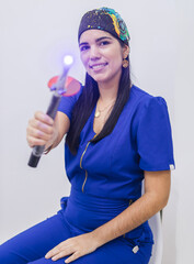 Portrait of a young professional dentist specializing in orthodontics shows a photopolymerizer